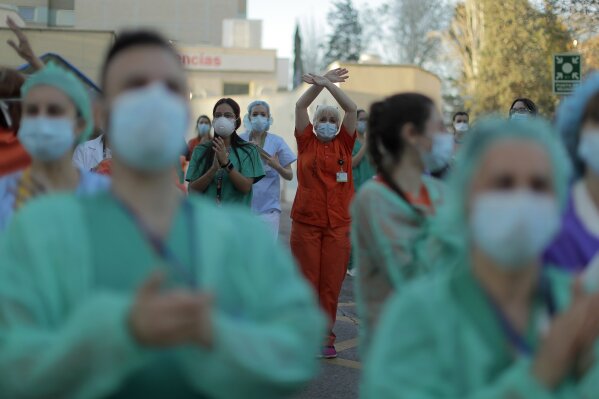 Health workers applaud as people react from their houses in support of the medical staff that are working on the COVID-19 virus outbreak at the Gregorio Maranon hospital in Madrid, Spain, Wednesday, April 1, 2020. The new coronavirus causes mild or moderate symptoms for most people, but for some, especially older adults and people with existing health problems, it can cause more severe illness or death. (AP Photo/Manu Fernandez)