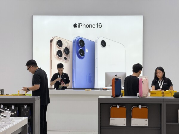 Sales staffs work at an Apple shop in Hanoi, Vietnam Thursday, April 10, 2025. (AP Photo/Hau Dinh, File)