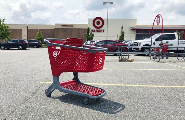 FILE - In this June 3, 2019, file photo a shopping cart sits in the parking lot of a Target store in Marlborough, Mass. Plenty of retailers like Target and Walmart allow shoppers to drop off online returns at their stores. But now, a growing number of retailers are accepting rivals’ returns. (AP Photo/Bill Sikes, File)