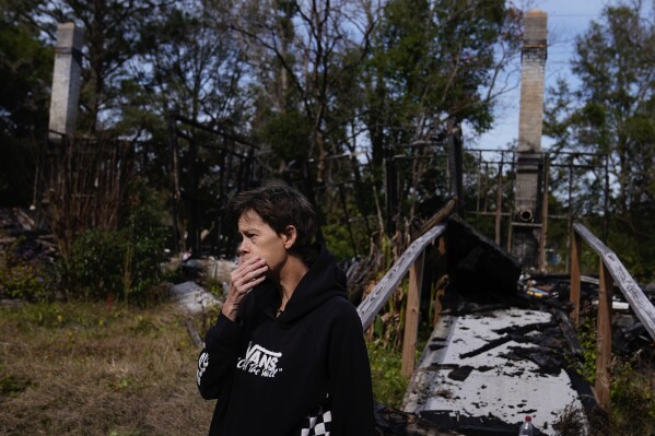 Lisa McGuire stands near her former walkway on Thursday, Dec. 7, 2023, as she describes a fire that engulfed her home, killing her two dogs, in a Prichard, Ala., neighborhood with a history of severe water loss. When a neighbor called her about the fire, she said she rushed home to find firefighters with an empty hose attached to a hydrant. (Ǻ Photo/Brynn Anderson)