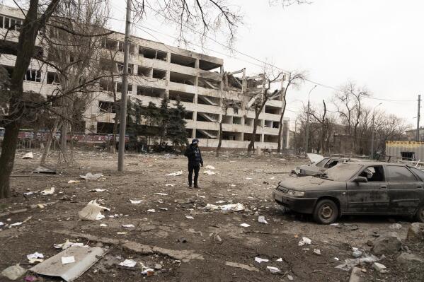 FILE - Associated Press photographer Evgeniy Maloletka stands amid rubble of an airstrike on Pryazovskyi State Technical University on March 10, 2022, in Mariupol, Ukraine. Maloletka and Mstyslav Chernov, two Ukrainians who documented the horrors of the Russian invasion and siege of Mariupol for The Associated Press, are being honored for their courage with Colby College's Lovejoy Award. (AP Photo/Mstyslav Chernov, File)