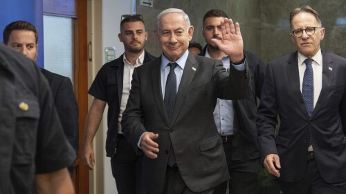 Israeli Prime Minister Benjamin Netanyahu, center, waves to the media as he arrives to the cabinet meeting at the prime minister's office in Jerusalem, Monday, July 17, 2023. (AP Photo/Ohad Zwigenberg, Pool)