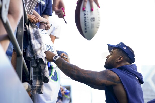 Seattle Seahawks safety Jamal Adams signs autographs for fans following the NFL football team's mock game Friday, Aug. 4, 2023, in Seattle. (AP Photo/Lindsey Wasson)