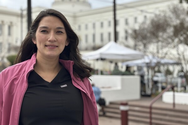 Cancer survivor Kailani Greenwood, who became pregnant through IVF, stands outside the capitol in Montgomery, Ala., during a rally on Feb. 28, 2024. She’s been trying to stay hopeful that IVF will resume at her clinic. But each day brings fresh reminders of the court decision. She works as a physician assistant in surgical breast oncology, and many of her patients hope to preserve their fertility too. (AP Photo/Kim Chandler)