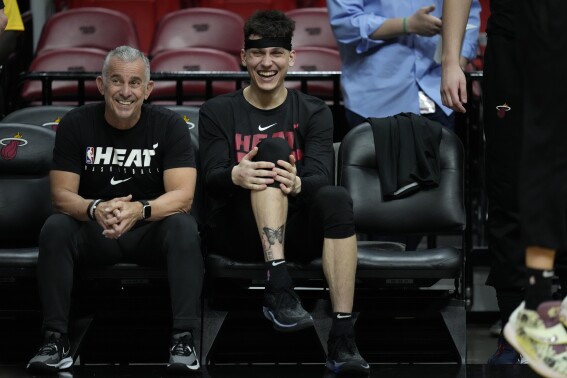 Miami Heat guard Tyler Herro, right, laughs as he watches from the bench during a practice ahead of Game 3 of the NBA Finals, at the Kaseya Center in Miami, Tuesday, June 6, 2023. (AP Photo/Rebecca Blackwell)