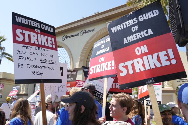 FILE - Striking Writers Guild members hold signs during a rally in front of Paramount Pictures studio in Los Angeles on May 17, 2023. Hollywood actors may be on the verge of joining screenwriters in what would be the first two-union strike in the industry in more than six decades. (AP Photo/Chris Pizzello, File)