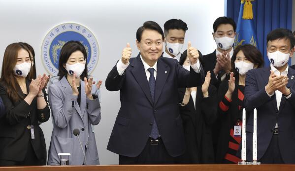South Korea President Yoon Suk Yeol, center, celebrates the successful launch of the Nuri rocket, the first domestically produced space rocket, at the presidential office in Seoul, South Korea, Tuesday, June 21, 2022. South Korea launched its first domestically built space rocket on Tuesday in the country's second attempt, months after its earlier liftoff failed to place a payload into orbit. (Ahn Jung-won/Yonhap via AP)