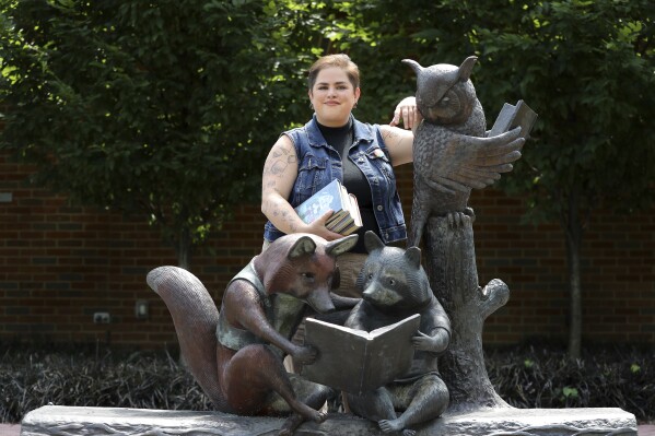 Chaz Carey poses for a photo at a library in Worthington, Ohio, Tuesday, June 11, 2024. Carey, a youth services librarian who is queer, knows firsthand how powerful books can be. Alison Bechdel's 2006 graphic memoir “Fun Home," in which the author comes to grips with her sexual orientation, changed Carey's life as a teenager. (AP Photo/Joe Maiorana)