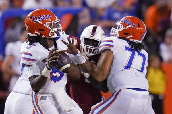 Florida quarterback Emory Jones, left, throws a pass as he get a block from offensive lineman Ethan White (77) during the first half of the team's NCAA college football game against Florida Atlantic, Saturday, Sept. 4, 2021, in Gainesville, Fla. (AP Photo/John Raoux)