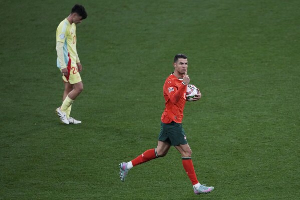 Portugal's Cristiano Ronaldo, right, celebrates after scoring his side's second goal against Spain during the Nations League final soccer match between Portugal and Spain at the Allianz Arena in Munich, Germany, Sunday, June 8, 2025. (AP Photo/Michael Probst)