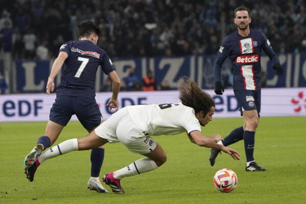 PSG's Vitor Machado, left, challenges for the ball with Marseille's Matteo Guendouzi during the French Cup soccer match between Olympique de Marseille and Paris Saint Germain at the Velodrome stadium in Marseille, southern France, Wednesday, Feb. 8, 2023. (AP Photo/Laurent Cipriani)
