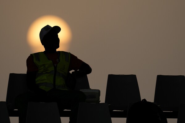 A member of security sits in the stands as the sun sets in the background before the African Cup of Nations quarter final soccer match between Cape Verde and South Africa, at the Charles Konan Banny stadium in Yamoussoukro, Ivory Coast, Saturday, Feb. 3, 2024. (APPhoto/Themba Hadebe)