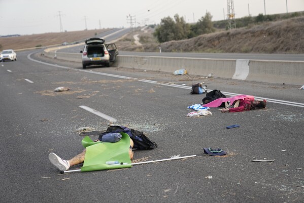 Israelis killed by Hamas militants lie on the road near Sderot, Israel, on Saturday, Oct. 7, 2023. Palestinian militants from the Gaza Strip infiltrated southern Israel Saturday and fired thousands of rockets into the country, prompting Israel to begin striking targets in Gaza in response. (AP Photo/Ohad Zwigenberg)