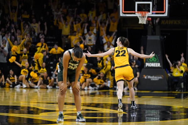 Iowa guard Caitlin Clark, right, celebrates in front of Michigan State guard Moira Joiner, left, after her three-point basket at the end of an NCAA college basketball game, Tuesday, Jan. 2, 2024, in Iowa City, Iowa. Iowa won 76-73. (AP Photo/Charlie Neibergall)