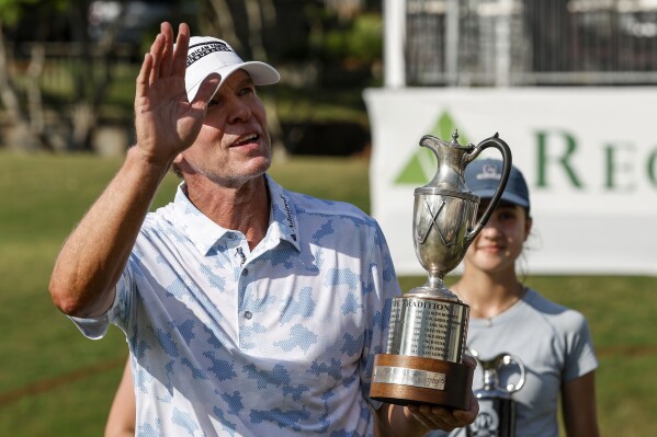 FILE - Steve Stricker celebrates with the trophy after winning a Champions Tour golf tournament, Sunday, May 14, 2023, in Hoover, Ala. Stricker won three of the four senior majors he played this year and already has set a record for most earnings in a season.(AP Photo/Butch Dill, File)