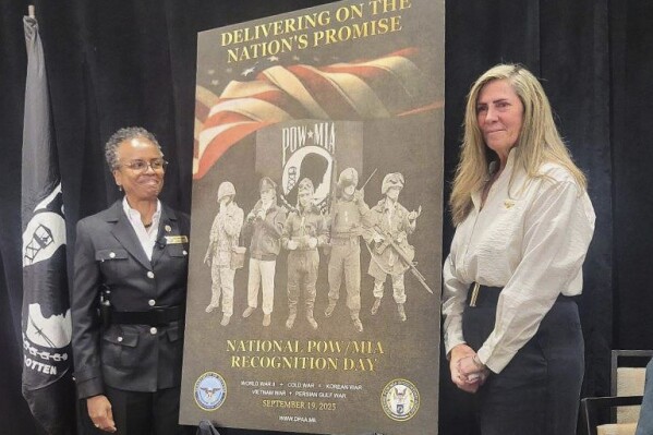 This photo provided by Jeanie Jacobs Huffman shows her, right, with Principle Deputy Director of Defense POW/MIA Accounting Agency Fern Sumpter Winbush, left, during an unveiling ceremony for the 2025 National Recognition Day poster. (Dave Huffman/Jeanie Jacobs Huffman via AP)