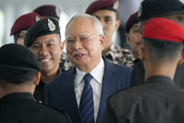 Former Malaysian Prime Minister Najib Razak arrives at the Kuala Lumpur High Court complex escorted by prison officers in Kuala Lumpur, Malaysia, April 4, 2024. (AP Photo/Vincent Thian, File)
