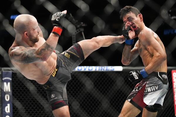 FILE - Alexander Volkanovski, left, kicks Max Holloway in a featherweight title bout during a UFC 276 mixed martial arts event on July 2, 2022, in Las Vegas. The taunts from UFC lightweight champion Islam Makhachev about a supposed lack of size aren’t likely to unsettle Volkanovski. (AP Photo/John Locher, File)