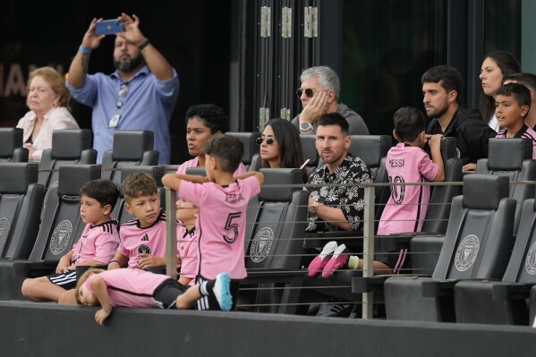 Inter Miami forward Lionel Messi, center right, sits with his family in a sideline box during the first half of an MLS soccer match against CF Montreal, Sunday, March 10, 2024, in Fort Lauderdale, Fla. (AP Photo/Rebecca Blackwell)