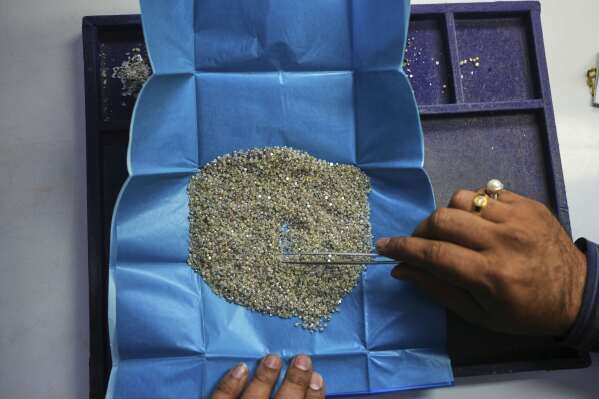 A trader inspects diamonds at his office in Surat, India, on April 14, 2025. (AP Photo/Ajit Solanki)