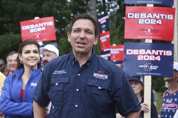 FILE - Republican presidential candidate and Florida Gov. Ron DeSantis and his wife Casey, walk in the July 4th parade, July 4, 2023, in Merrimack, N.H. DeSantis is defending an anti-LGBTQ video his campaign shared online that attacks rival Donald Trump for his past support of gay and transgender people, despite some of his fellow Republicans calling it homophobic. (AP Photo/Reba Saldanha, File)