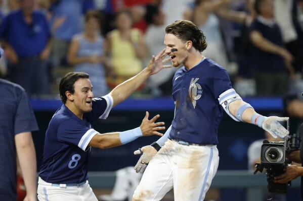 Kansas City Royals' Bobby Witt Jr., right, celebrates with Nicky Lopez at home plate after hitting a grand slam against the Minnesota Twins during the 10th inning of a baseball game in Kansas City, Mo., Friday, July 28, 2023. (AP Photo/Colin E. Braley)