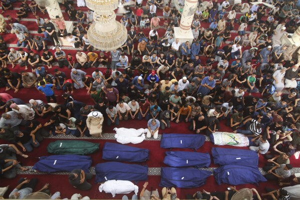 Những người đưa tang cầu nguyện bên thi thể của các thành viên gia đình Salem Abu Quta, một chiến binh Hamas, trong đám tang sau khi họ bị giết trong một cuộc tấn công của Israel vào ngôi nhà của họ ở trại tị nạn Rafah, phía nam Dải Gaza, Chủ nhật, ngày 8 tháng 10 năm 2023. (Ảnh AP) /Hát Ali)