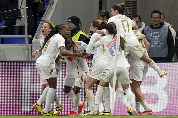 Lyon's Melchie Dumornay, 3rd left, celebrates after scoring her side's second goal during the women's Champions League semifinals, first leg, soccer match between Olympique Lyonnais and Paris Saint-Germain at Parc Olympique Lyonnais, in Lyon, France, Saturday, April 20, 2024. (AP Photo/Laurent Cipriani)