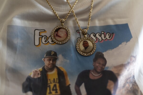 Charlene Roberts wears necklaces with portraits of her children lost to gun violence Friday, Aug. 4, 2023 in Knoxville, Tenn. (AP Photo/George Walker IV)