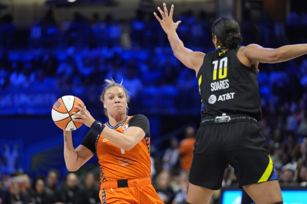 Connecticut Sun guard Rachel Banham (1) looks to pass as Dallas Wings center Stephanie Soares (10) defends during the second half of a WNBA basketball basketball game in Arlington, Texas, Saturday, June 15, 2024. (AP Photo/LM Otero)