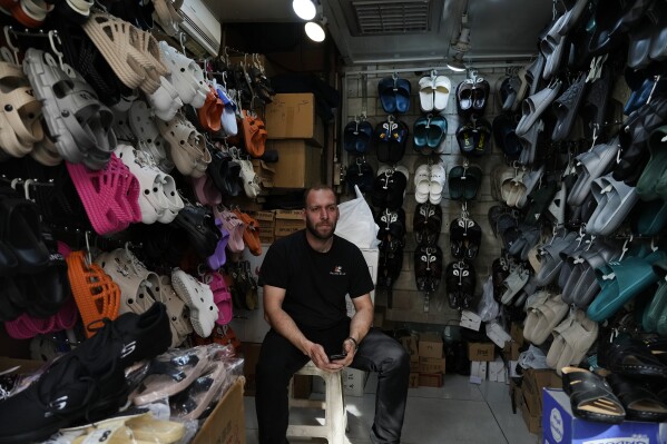 A shopkeeper sits at his shop at the old main bazaar in Tehran, Iran, Tuesday, April 16, 2024. Israel says it is poised to retaliate against Iran, risking further expanding the shadow war between the two foes into a direct conflict after an Iranian attack over the weekend sent hundreds of munitions into Israeli airspace. (AP Photo/Vahid Salemi)