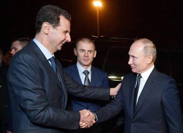 Russian President Vladimir Putin, right, and Syrian President Bashar Assad shake hands during their meeting in Damascus, Syria, Tuesday, Jan. 7, 2020. Putin has traveled to Syria to meet with President Bashar Assad, a key Iranian ally. The rare visit Tuesday comes amid soaring tensions between Iran and the United States following the U.S. drone strike last week that killed a top Iranian general who led forces supporting Assad in Syria's civil war. (Alexei Druzhinin, Sputnik, Kremlin Pool Photo via AP)
