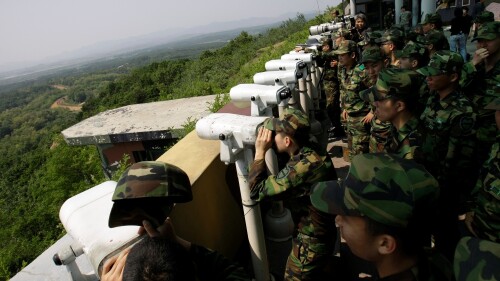FILE - South Korean soldiers look at the North Korean side through binoculars at Dora Observation Post in the demilitarized zone, DMZ, near the border village of Panmunjom that separates the two Koreas since the Korean War, in Paju, north of Seoul, South Korea, Wednesday, May 27, 2009. A series of low-slung buildings and somber soldiers dot the landscape of the DMZ, the swath of land between North and South Korea where a soldier on a tour crossed into North Korea on Tuesday, July 18, 2023, under circumstances that remain unclear. (AP Photo/Lee Jin-man, File)