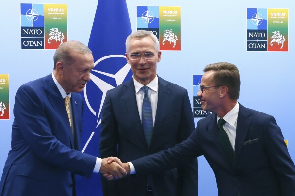 FILE - Turkey's President Recep Tayyip Erdogan, left, shakes hands with Sweden's Prime Minister Ulf Kristersson, right, as NATO Secretary General Jens Stoltenberg looks on prior to a meeting ahead of a NATO summit in Vilnius, Lithuania, Monday, July 10, 2023. The Turkish Parliament’s foreign affairs committee is set to debate Sweden’s bid to join NATO on Thursday, Nov. 16, 2023 drawing the country closer to membership in the Western military alliance. (Yves Herman, Pool Photo via AP, File)