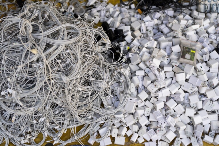 Used charging cables and power adapters are piled up at a shop in Nhat Tao market, the largest informal recycling market in Ho Chi Minh City, Vietnam, Sunday, Jan. 28, 2024. (AP Photo/Jae C. Hong)