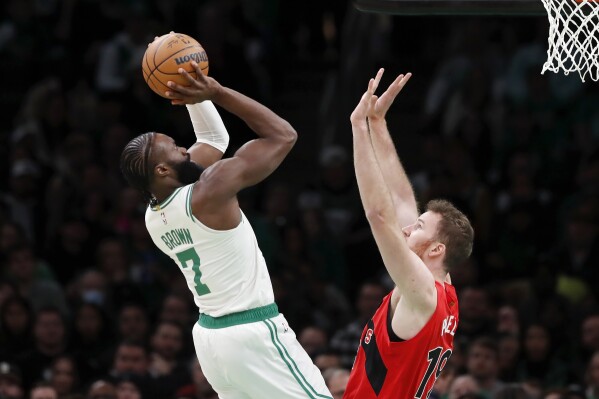 Boston Celtics' Jaylen Brown (7) shoots over Toronto Raptors' Jakob Poeltl (19) during the first half of an NBA basketball game, Saturday, Nov. 11, 2023, in Boston. (AP Photo/Michael Dwyer)