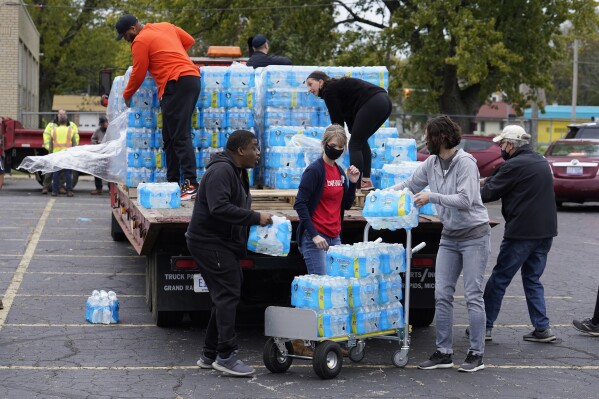 FILE - Volunteers prepare bottled water to be distributed to residents at the local high school parking lot Oct. 21, 2021, in Benton Harbor, Mich. The Environmental Protection Agency will soon strengthen lead in drinking water regulations. (AP Photo/Charles Rex Arbogast, File)
