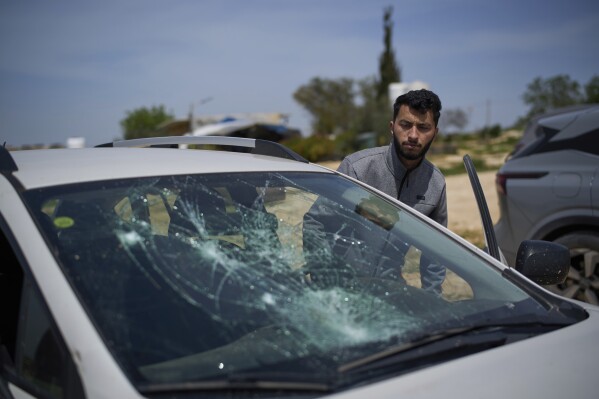 Basel Adra, Palestinian co-director of the Oscar winner documentary "No Other Land", looks at a damaged car after a settler's attack in the village of Susiya in Masafer Yatta, south Hebron hills, March 25, 2025. (AP Photo/Leo Correa, file)