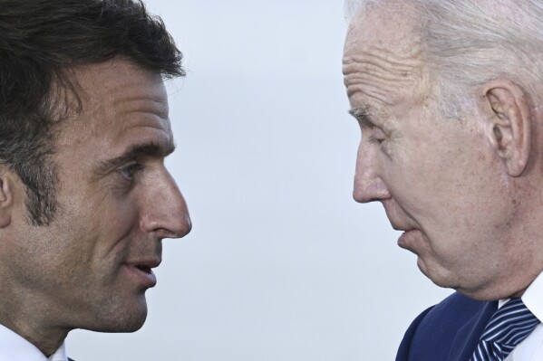 FILE - France's President Emmanuel Macron, left, speaks with U.S. President Joe Biden during a family photo of leaders of the G7 and invited countries during the G7 Leaders' Summit in Hiroshima, western Japan, Saturday, May 20, 2023. French President Emmanuel Macron's office said Thursday that U.S. President Joe Biden will make his first state visit to France next week after attending D-Day 80th anniversary commemorations in Normandy. Macron will be hosting Biden and his wife Jill on June 8, the statement said. (Brendan Smialowski/Pool Photo via AP, File)