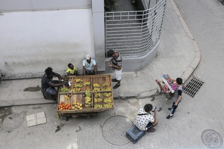 A vendor sells his produce from a cart, in Havana, Cuba, Wednesday, March 13, 2024. Without a functioning market economy, Cuban agriculture has long measured itself by socialist production goals that it has rarely been able to meet. (AP Photo/Ariel Ley)