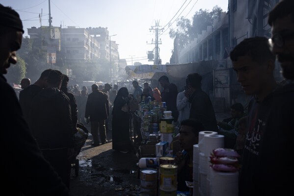 Palestinians buy goods at a street market in Rafah, Gaza Strip, Tuesday, Feb. 20, 2024.An estimated 1.5 million Palestinians displaced by the war took refuge in Rafahor, which is likely Israel's next focus in its war against Hamas. (AP Photo/Fatima Shbair)
