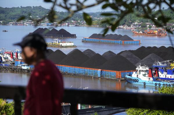 Coal barges are anchored on Mahakam River in Samarinda, East Kalimantan, Indonesia, Monday, Dec. 19, 2022. Indonesia, one of the world's largest coal-producing countries, has agreed to drastically reduce its reliance on fossil fuels in the coming decades.(AP Photo/Dita Alangkara)