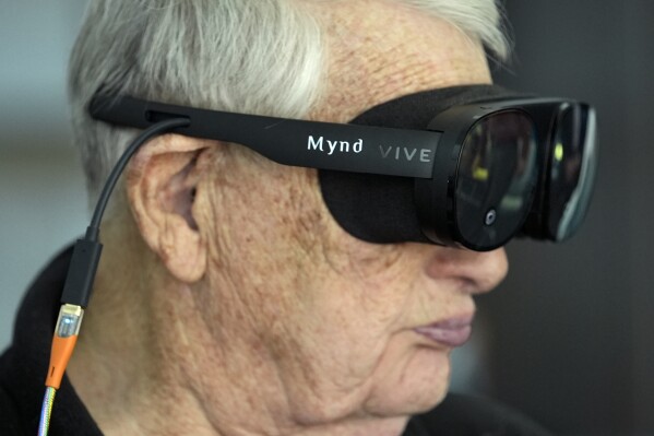 Retired Army Col. Farrell Patrick, 91, wears a Mynd Immersive virtual reality headset at John Knox Village, Wednesday, Jan. 31, 2024, in Pompano Beach, Fla. John Knox Village was one of 17 senior communities around the country that participated in a recently published Stanford University study that found that large majorities of 245 participants between 65- and 103-years-old enjoyed virtual reality, improving both their emotions and their interactions with staff. (APPhoto/Lynne Sladky)