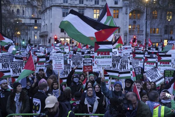 People take part in a Palestine Solidarity Campaign rally outside the Houses of Parliament as MPs debate calls for a ceasefire in Gaza, in London, Wednesday Feb. 21, 2024. (Lucy North/PA via AP)