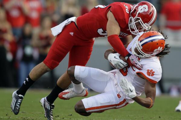 North Carolina State's Brandan Bishop (30) tackles Clemson's DeAndre Hopkins during the first half of an NCAA college football game in Raleigh, N.C., Saturday, Nov. 19, 2011. (AP Photo/Gerry Broome)