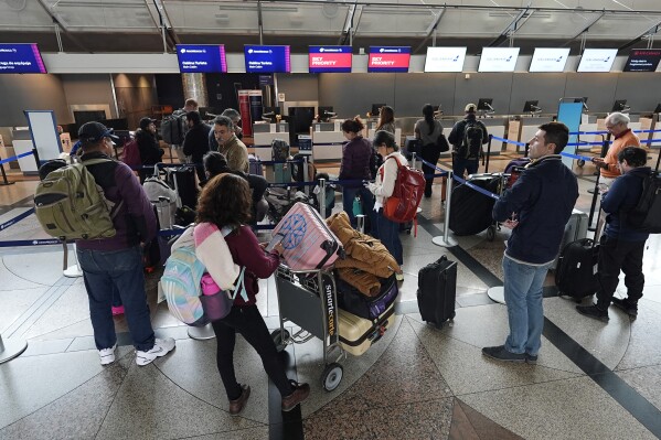 Travelers queue up for the check-in counter for Aeromexico Airlines Tuesday, April 16, 2024, in Denver International Airport in Denver. (AP Photo/David Zalubowski)