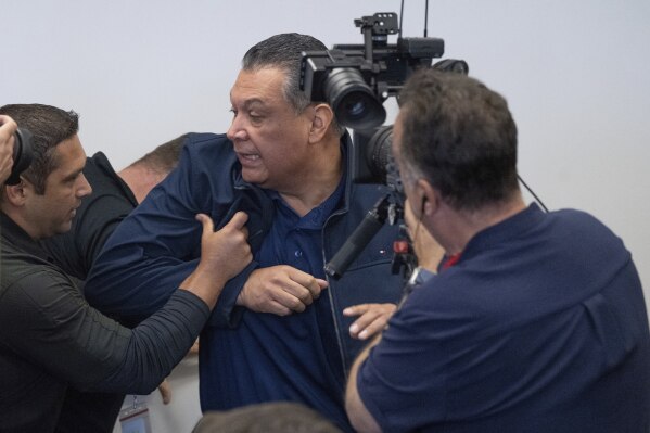 U.S. Sen. Alex Padilla, D-Calif., is pushed out of the room as Homeland Security Secretary Kristi Noem holds a news conference regarding the recent protests in Los Angeles, Thursday, June 12, 2025. (David Crane/The Orange County Register via AP)