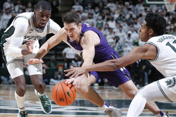 Northwestern's Ryan Greer, center, Michigan State's Gabe Brown, left, and Northwestern's A.J. Hoggard, right, vie for the ball during the first half of an NCAA college basketball game, Saturday, Jan. 15, 2022, in East Lansing, Mich. (AP Photo/Al Goldis)