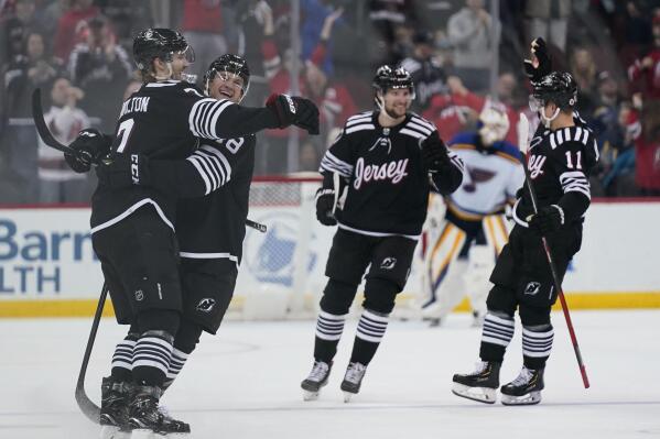 Teammates celebrate with New Jersey Devils' Dougie Hamilton, left, after he scored the winning goal in the overtime of the NHL hockey game against the St. Louis Blues in Newark, N.J., Sunday, March 6, 2022. The Devils defeated the Blues in overtime, 3-2. (AP Photo/Seth Wenig)