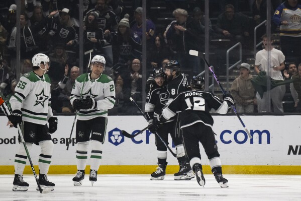 Los Angeles Kings left wing Kevin Fiala (22) celebrates his goal with defenseman Drew Doughty (8) and left wing Trevor Moore (12) during the first period of an NHL hockey game against the Dallas Stars, Saturday, March 9, 2024, in Los Angeles. (AP Photo/Kyusung Gong)